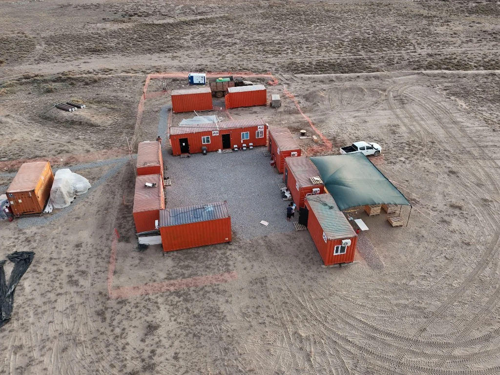 Вид с высоты на полевой лагерь: модули и техника на площадке геологоразведочной экспедиции
