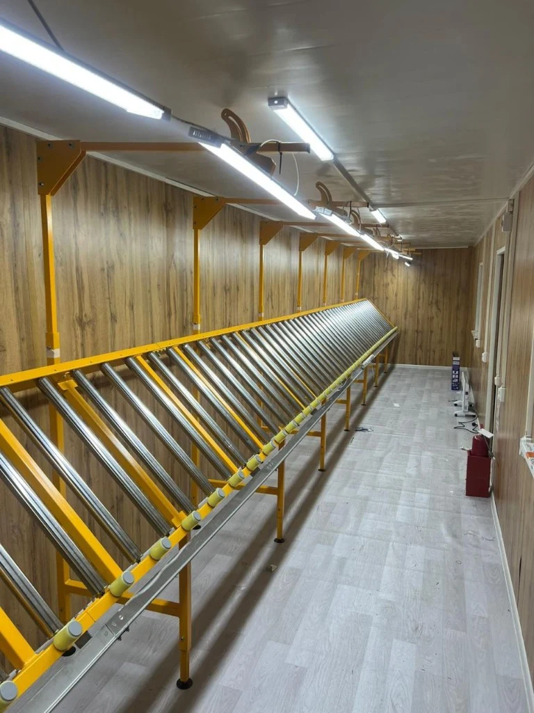 Интерьер документорской: длинный роликовый стол для укладки и описания керна, яркое LED-освещение и электрика вдоль стен